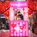 Pink inflatable kissing booth with hearts and a couple inside