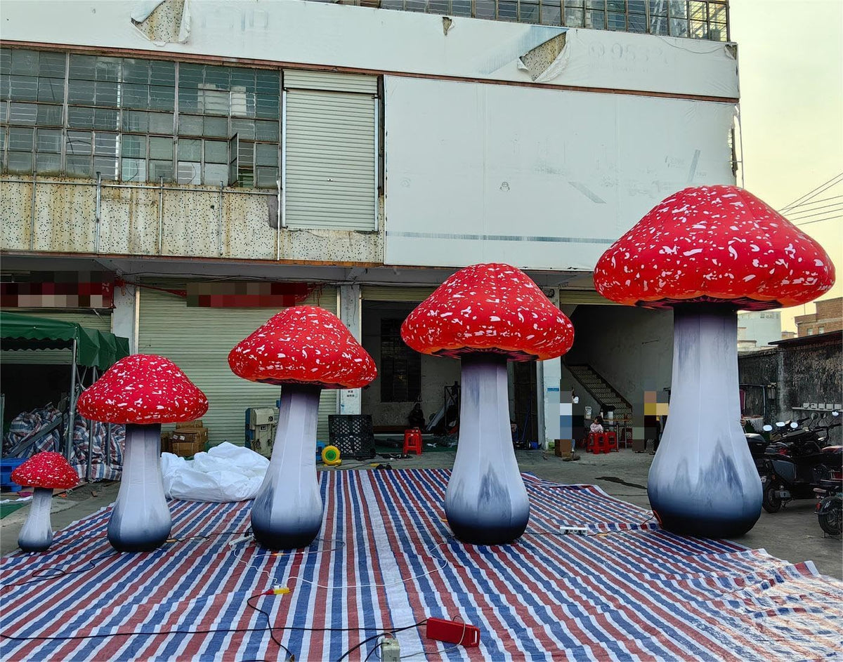 Several red-capped inflatable mushrooms with white spots on a plaza